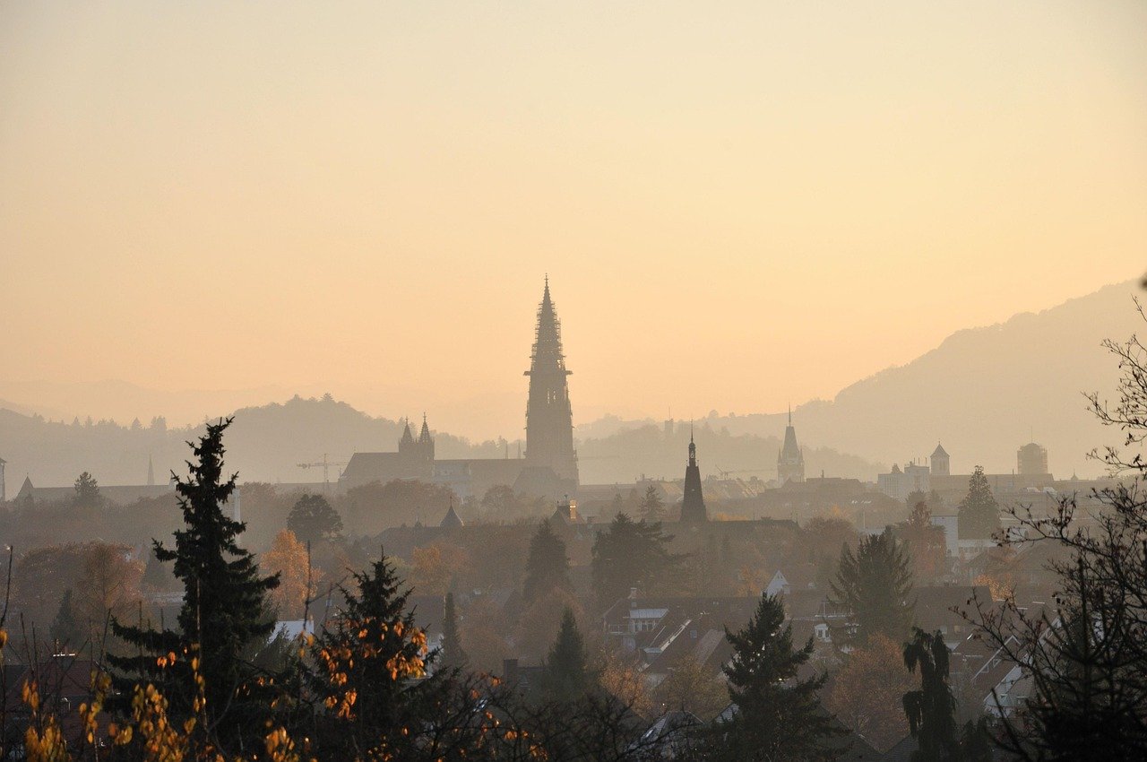 Blick über Freiburg bei Sonnenaufgang, Dunst in der Luft.